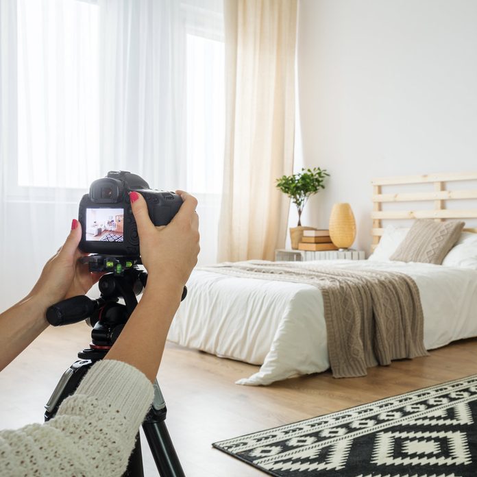 Woman takes a photo of a bedroom