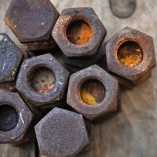 Old bolts or dirty bolts on wooden background, Machine equipment in industry work.