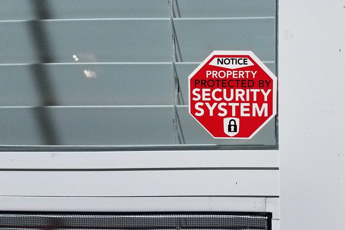 red generic property protected by security system sticker on window