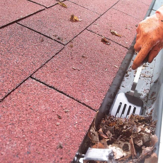 HH clean gutter with a spatula