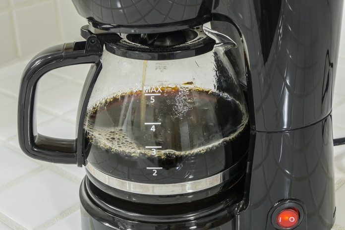 Coffee maker pot filling close up.