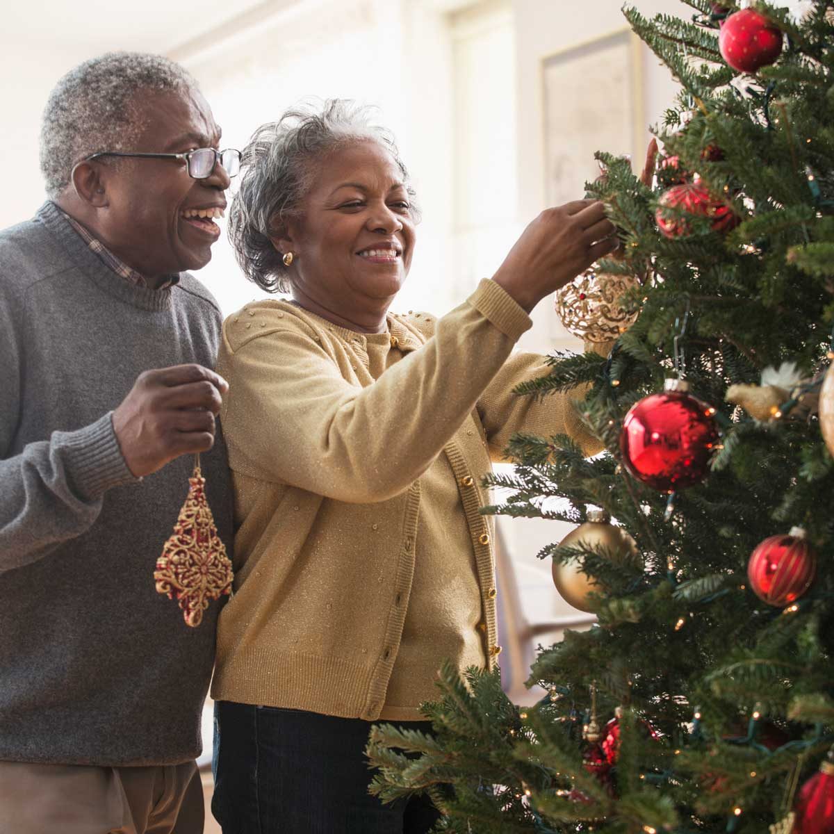 Older Black couple decorating a Christmas Tree