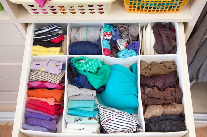 Women's clothing in the drawers of the wardrobe. Underwear, T-shirts and socks in the closet. Vertical storage.