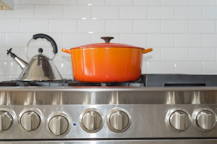 Bright orange pot on top of upscale home stove