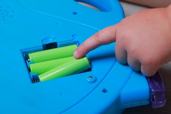 hand the child put the batteries in the blue toy