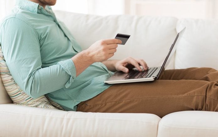 technology, shopping, banking, home and lifestyle concept - close up of man with laptop computer and credit card at home