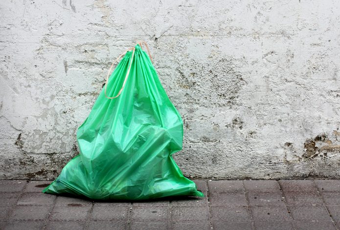 Green garbage bag on street