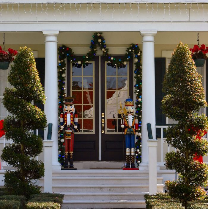 toy soldier christmas decoration on front porch with topiearies