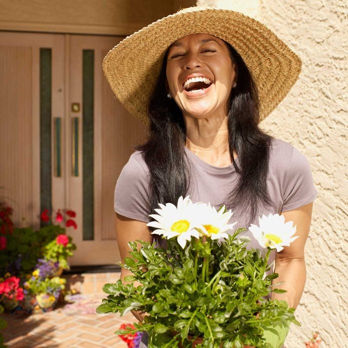 Woman planting flowers to increase curb appeal