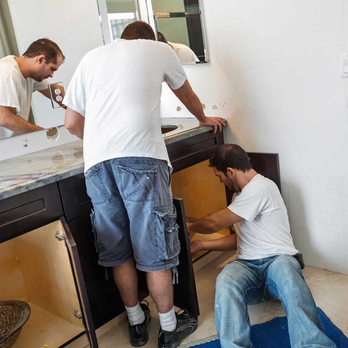 Two men installing a bathroom vanity