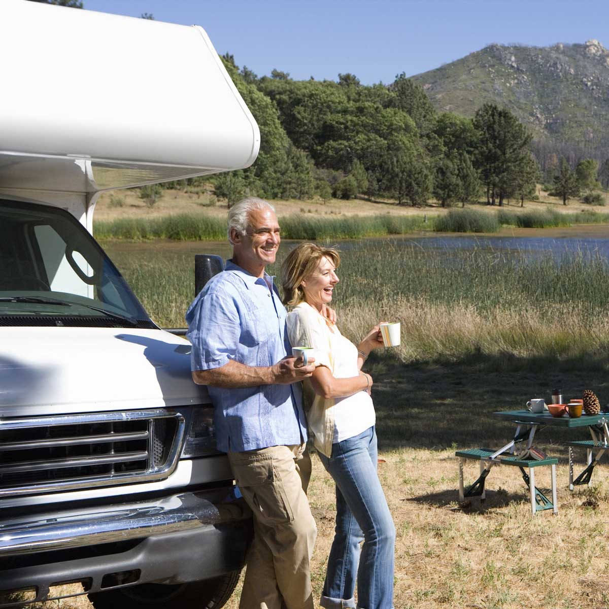Couple drinking coffee against their RV