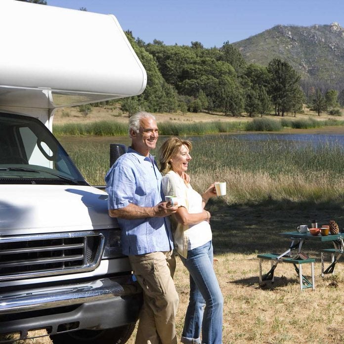 Couple drinking coffee against their RV