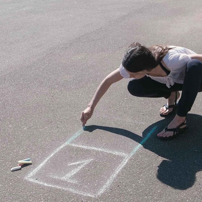 Woman drawing an agility ladder with chalk