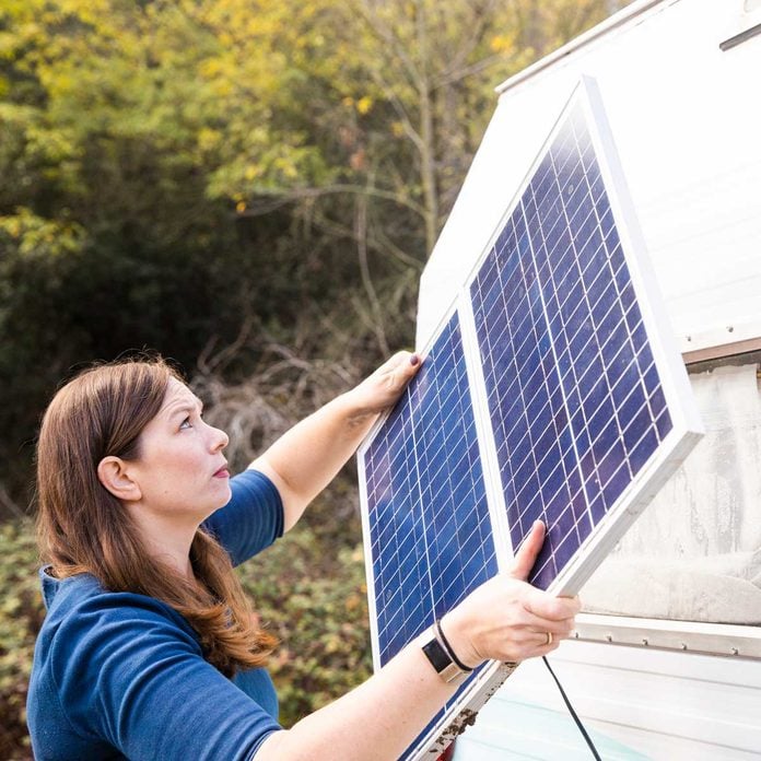 Woman adding solar panels to an RV