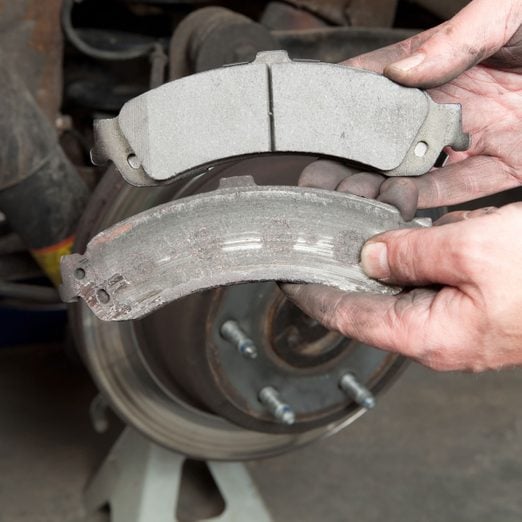 Photo of a worn rear brake pad next to a new rear brake pad