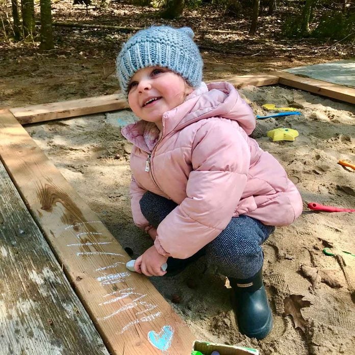 Little girl playing in a sand box