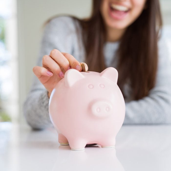 Woman putting money in a piggy bank