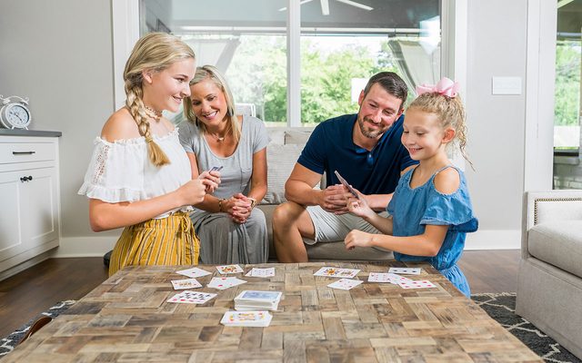 Family sitting around a table playing cards