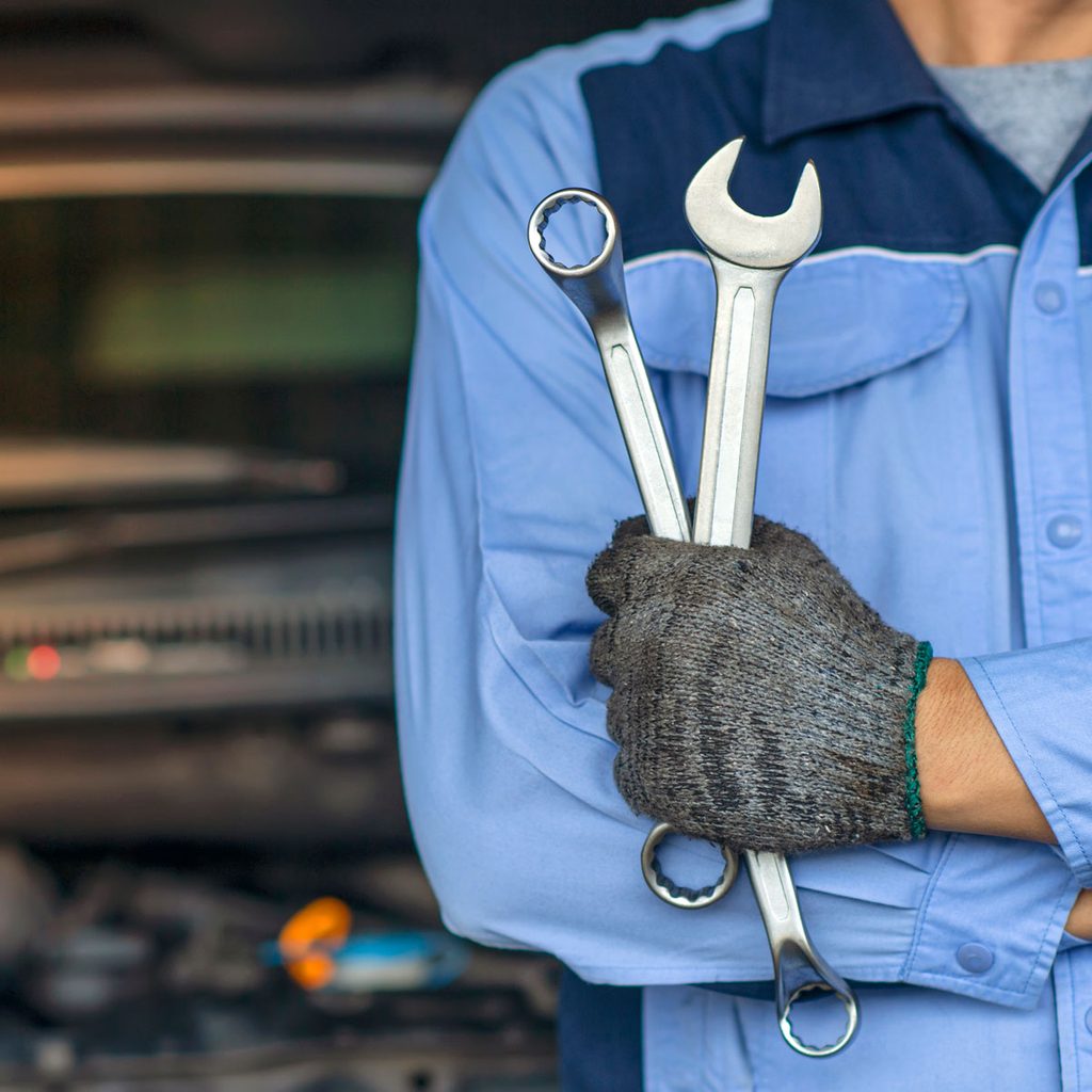 Mechanic holding wrenches
