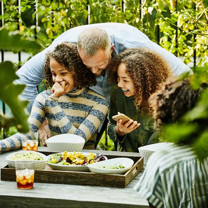 Father and daughters at an outdoor coffee table