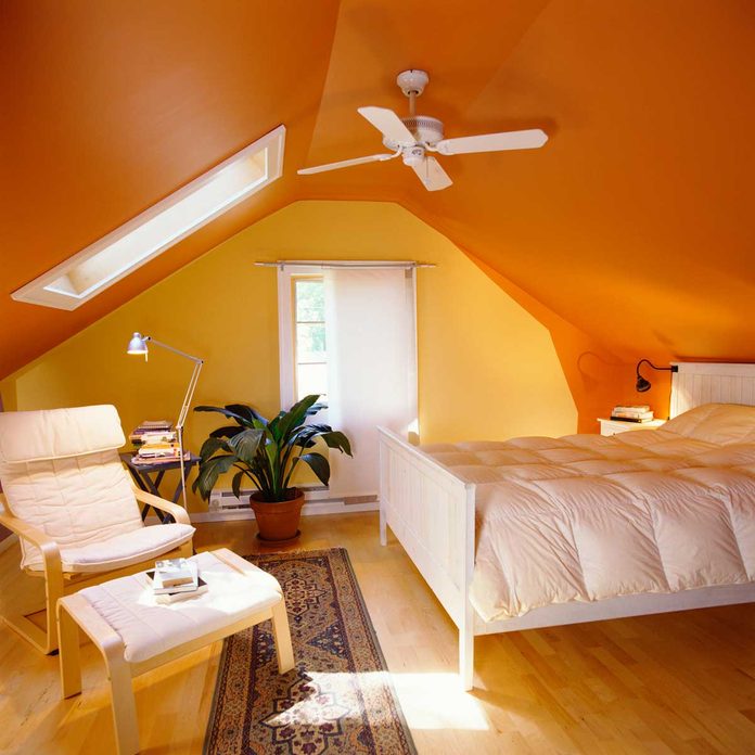 Orange bedroom with a ceiling fan