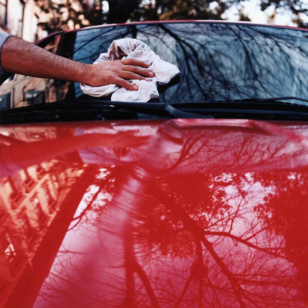 Man wiping a shiny red car