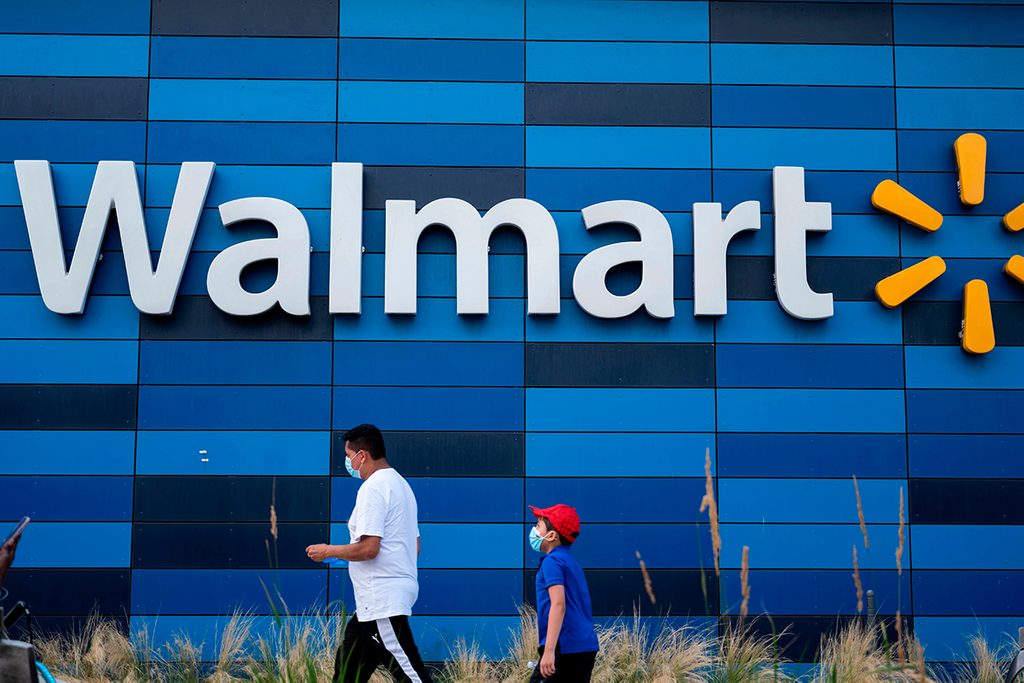 A man and child wearing facemasks walk in front of a Walmart store in Washington, DC on July 15, 2020. - Walmart will require shoppers to wear face masks starting next week, the US retail giant announced on July 15, joining an increasing number of businesses in mandating the protection amid the latest spike in coronavirus cases. (Photo by ANDREW CABALLERO-REYNOLDS / AFP) (Photo by ANDREW CABALLERO-REYNOLDS/AFP via Getty Images)