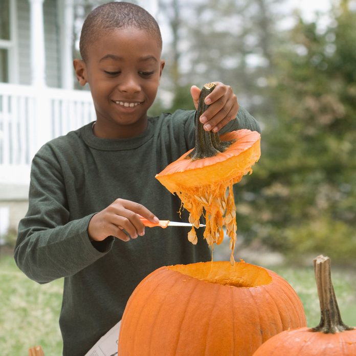 Kid carving a pumpkin