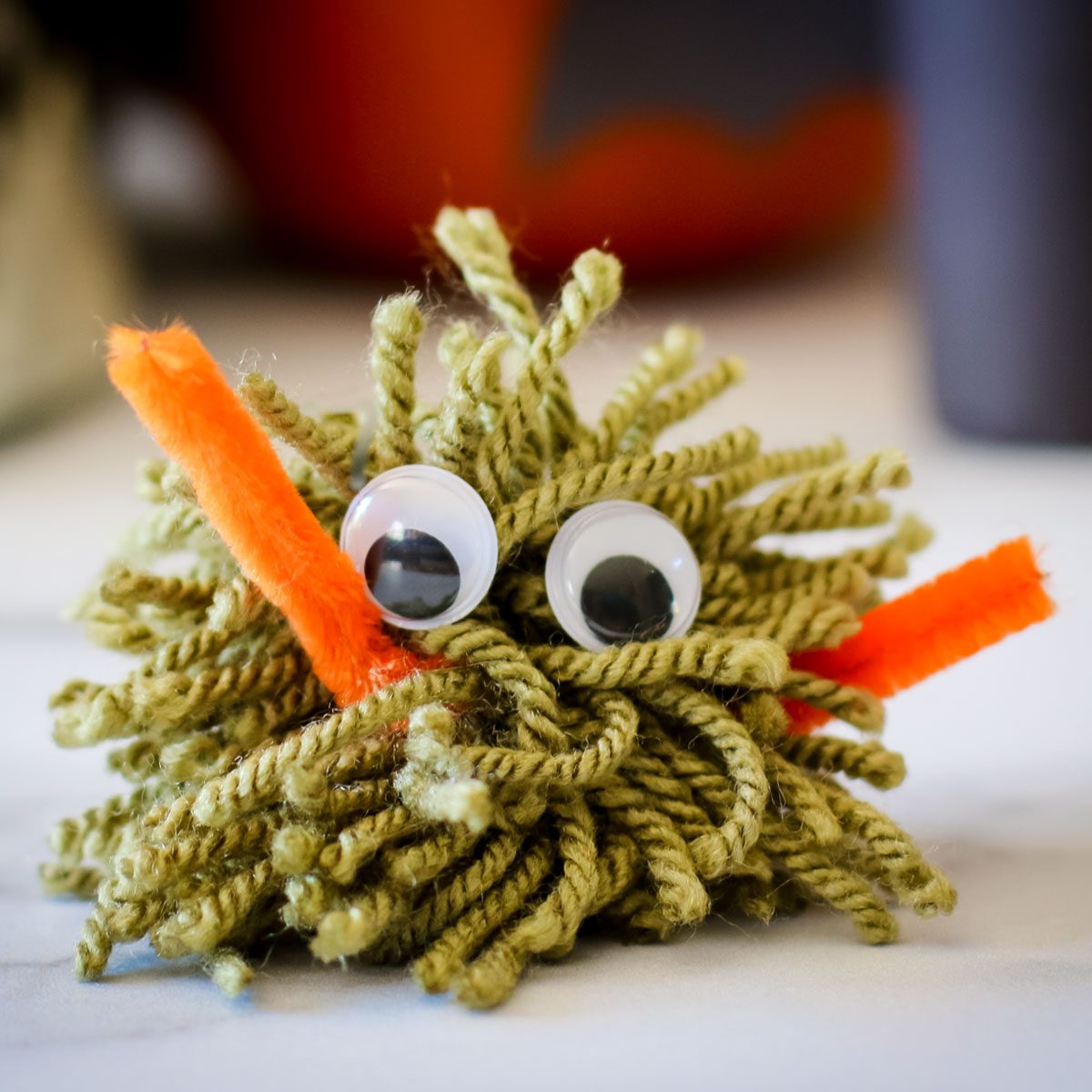 Yarn Monster craft madewith green yard and googly eyes
