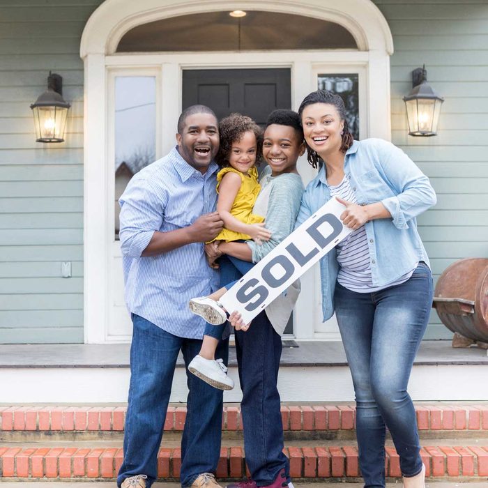 Family holding sold sign