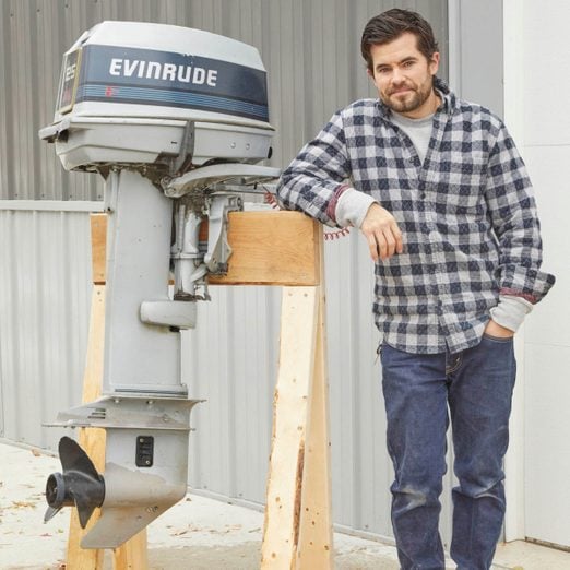 Man standing near a boat motor