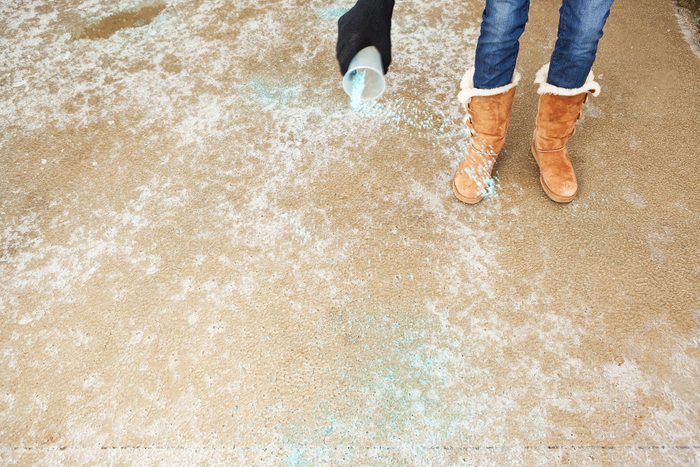 Spreading Salt On A Icy Winter Driveway