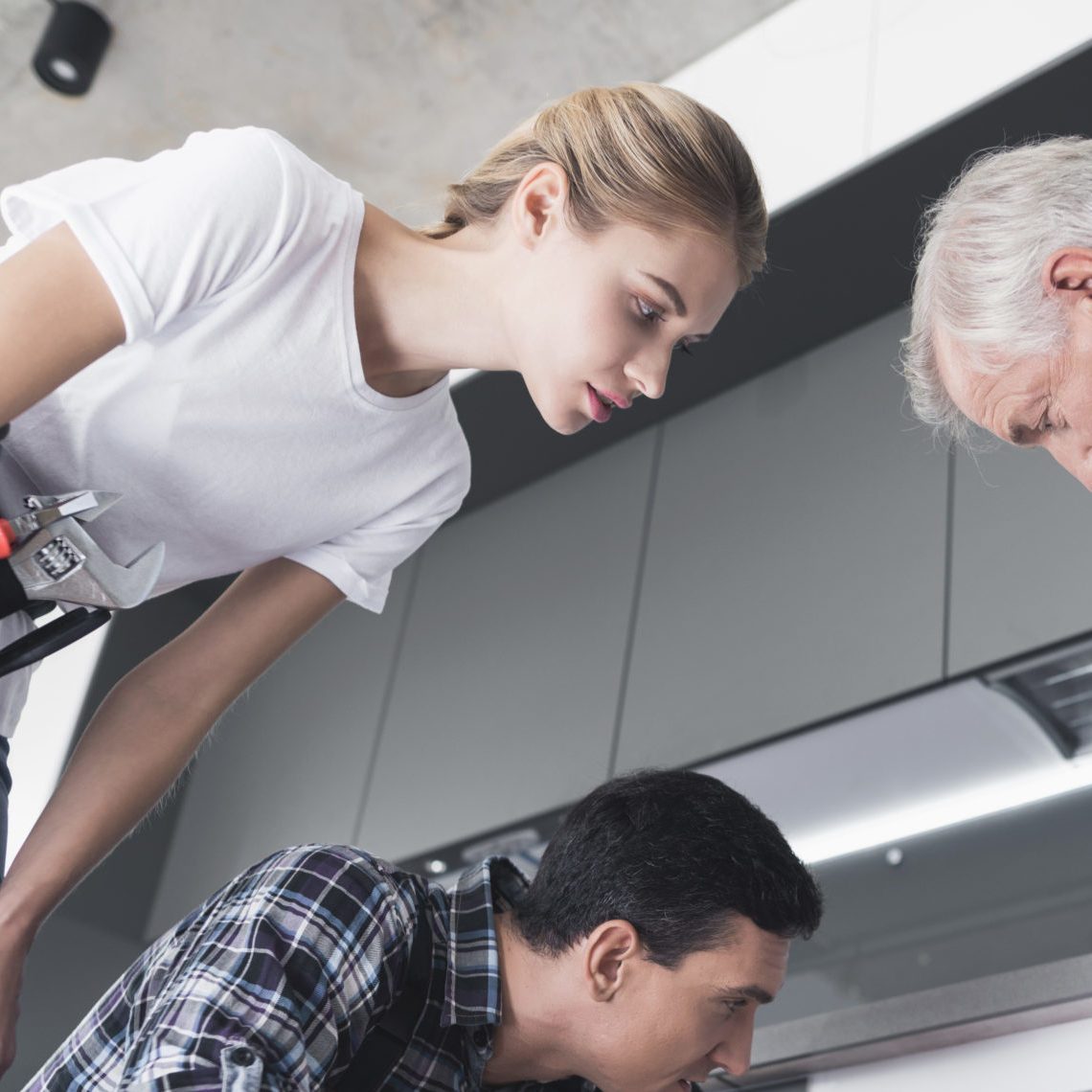 A man and a woman of sanitary engineering came to a call to an elderly man. He talks about the problem with the pipes. Young specialists inspect the place of the accident.