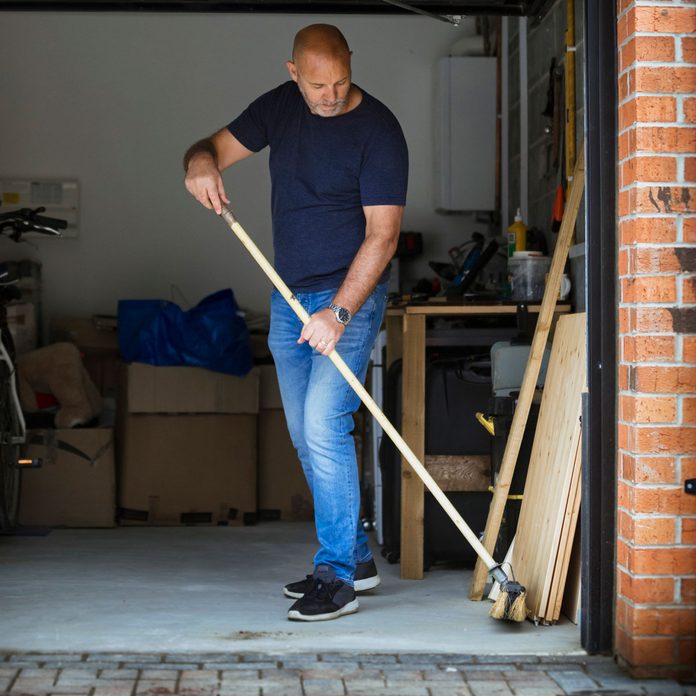 Man sweeping his garage floor