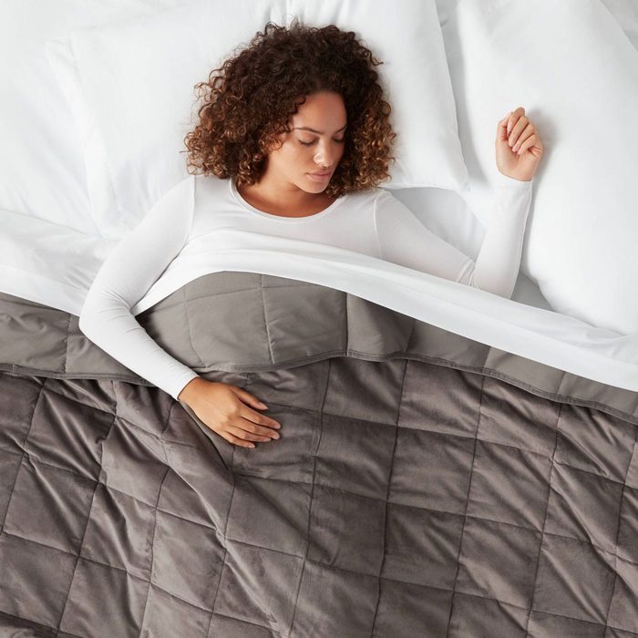 Woman sleeping under a weighted blanket