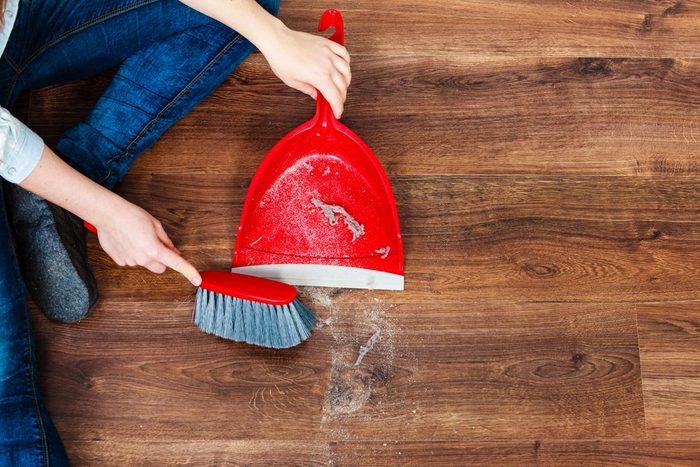 Cleanup Housework Concept Closeup Cleaning Woman Sweeping Wooden Floor With Red Small Whisk Broom And Dustpan Indoor