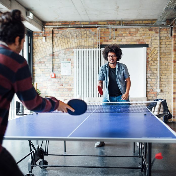 ping pong table playing table tennis with colleague Gettyimages 875610610