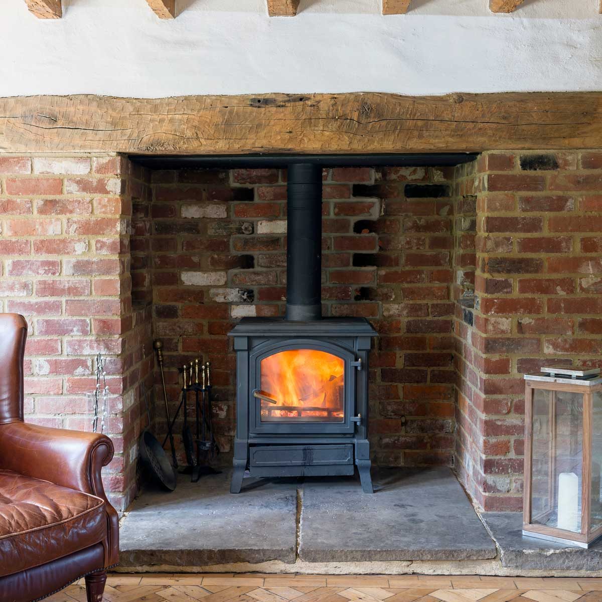 Wood stove in traditional brick fireplace