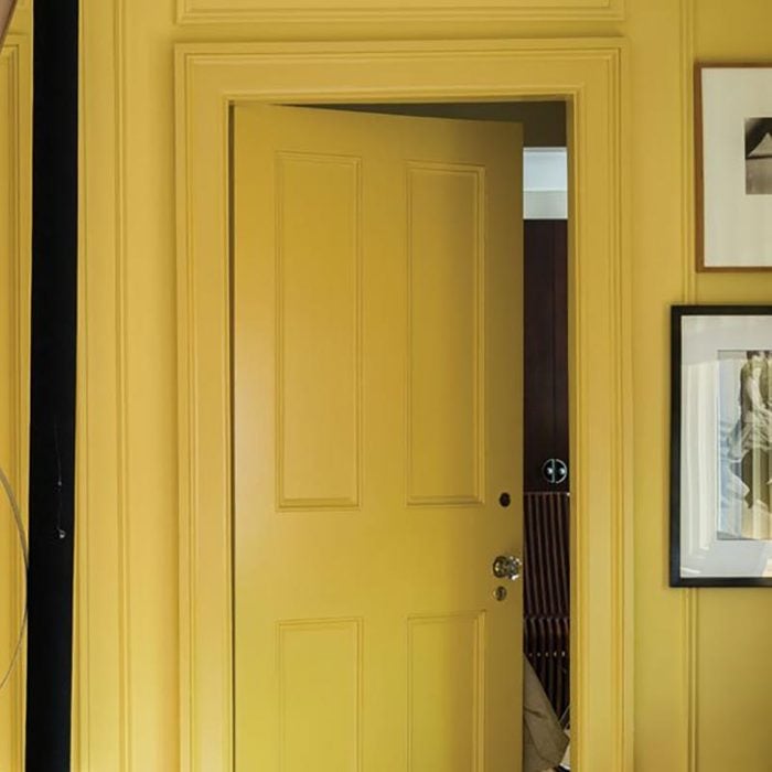 yellow door and walls with picture frames