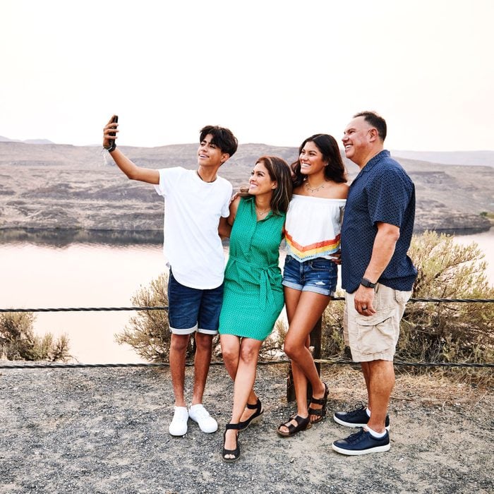 smiling family on vacation take a group selfie