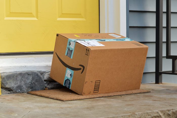 amazon box sitting on a front step near a yellow front door