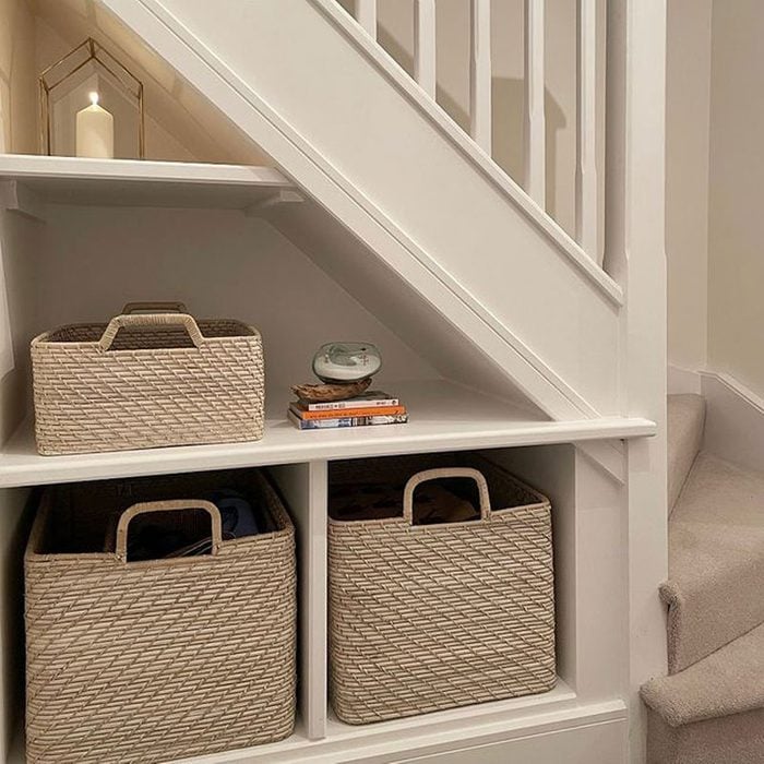 Shelving under the stairs with woven baskets