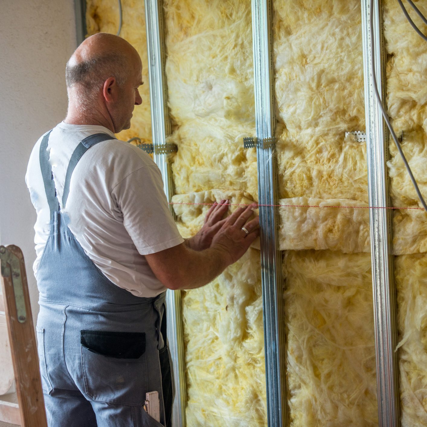 Man working on rock wool of an home wall