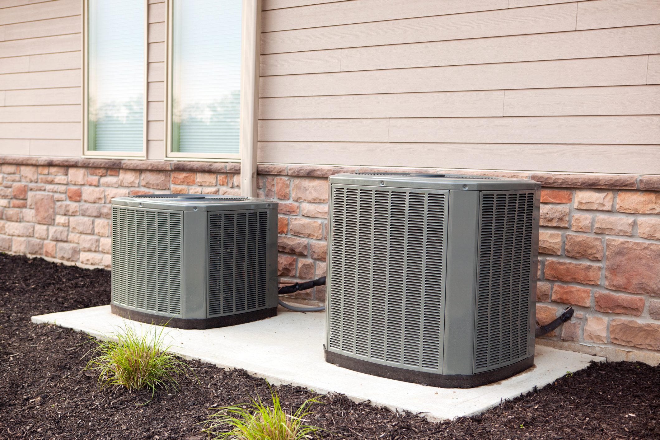 two central air conditioning units outside of house