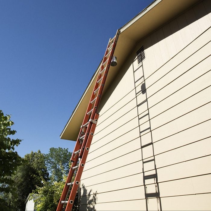 Tall ladder leaning on house
