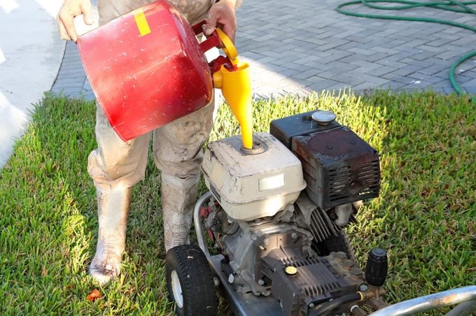 Series:unrecognizable Worker Filling A Power Washing Machine With Gasoline