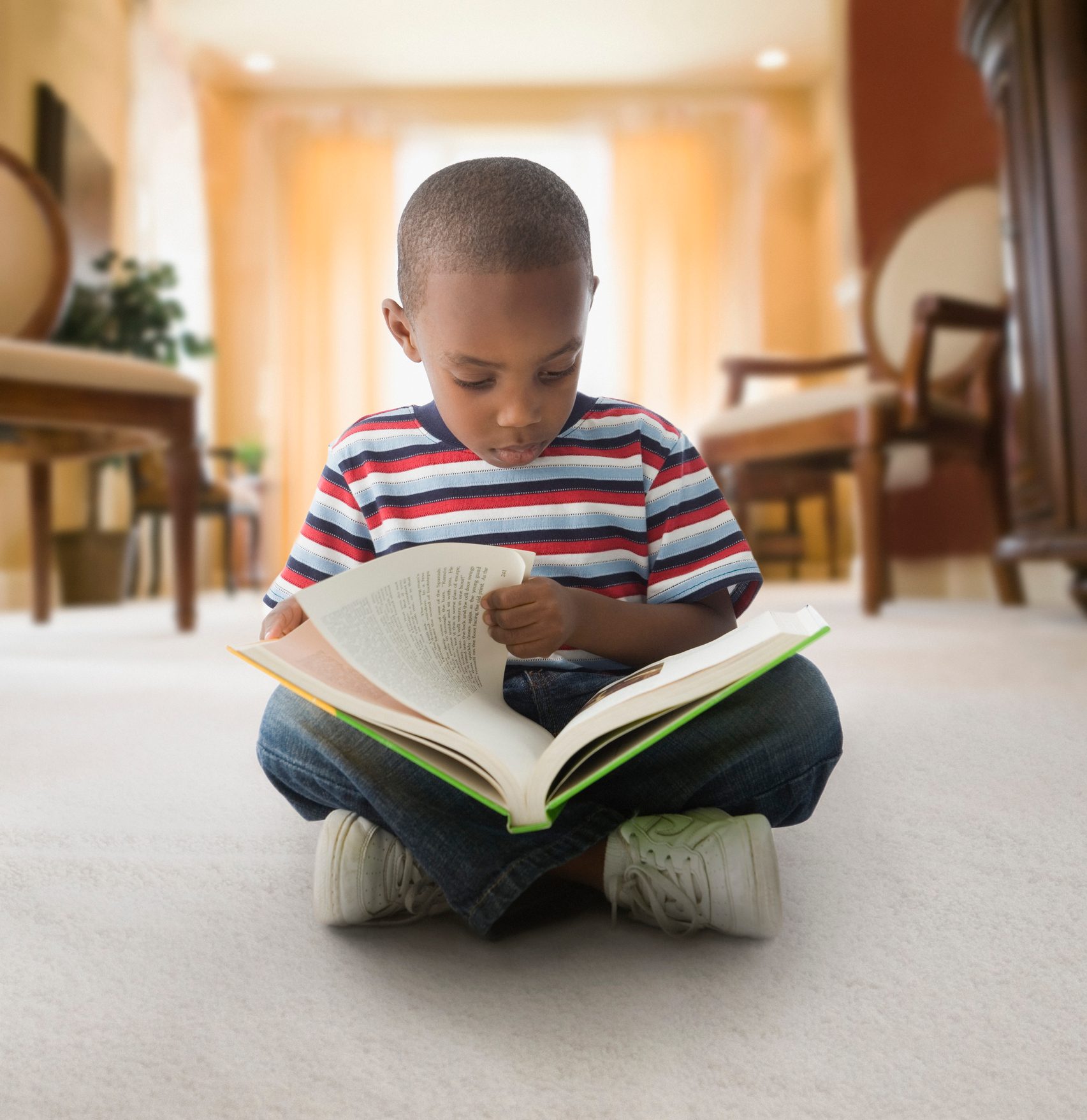 African American boy reading on floor