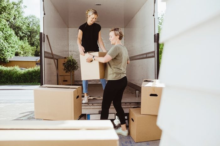 women loading moving boxes onto moving truck