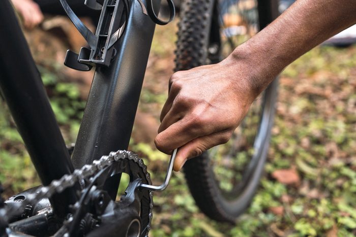 man using allen wrench to fix his bike 