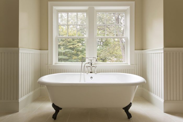 Clawfoot bathtub near the window in bathroom